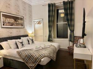 a bedroom with a bed with two towels on it at Brig O'Doon Guest House in Edinburgh