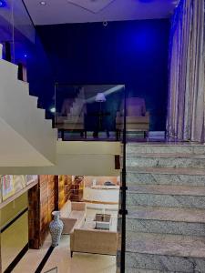 a room with a staircase with a blue wall at Eduardo Hotel in Dushekoro