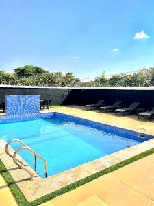 a large swimming pool with blue chairs at Eduardo Hotel in Dushekoro +29 photos
