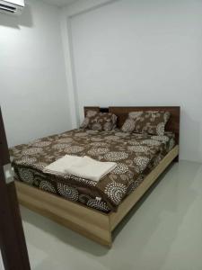 een bed in een kamer met een houten frame bij Lamai Home 2 in Ko Yao Noi