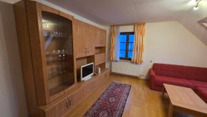 a living room with a red couch and a tv at Zettler Apartment in Großsölk