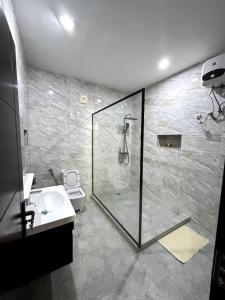 a bathroom with a shower and a sink at Eduardo Hotel in Dushekoro