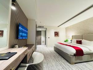 a hotel room with a large bed and a tv at TAJ HOTEL Executive Apartments - F7 Islamabad in Islamabad