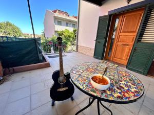 B&B Ginepro blu في بورتوسكوسو: وعاء من الحساء موضوع على طاولة بجانب جيتار