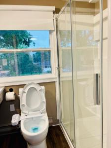 a bathroom with a toilet with a window and a shower at Comfort Room-Free Parking & Cozy Stay in Charlottetown in Charlottetown +25 photos