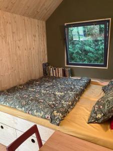 a bed in a room with a window at Tinyhouse v zahradě in Spělkov