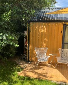 Dos sillas y una mesa en un patio. en Tinyhouse v zahradě, 
