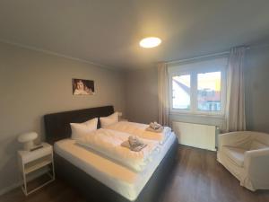 Un dormitorio con una cama, una silla y una ventana en Ruhige Oase & Vollausstattung - AS1A, en Weissenfels