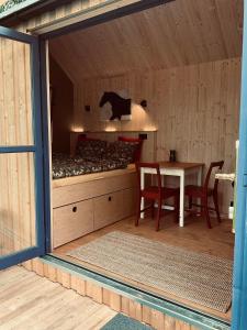 una habitación con una cama y una mesa en una cabaña en Tinyhouse v zahradě, 