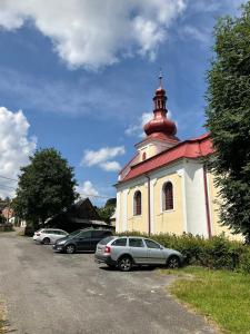 una pequeña iglesia con coches estacionados en un estacionamiento en Tinyhouse v zahradě, 