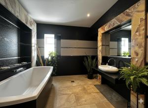 a bathroom with a tub and a sink and a mirror at Luxury Villa with pool 6 min to Football Stadium CAF in Rabat