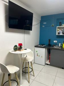 a kitchen with a table and two chairs and a tv at Studio F cosy in Cayenne