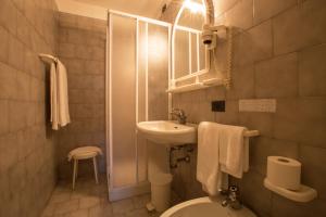 a small bathroom with a sink and a toilet at Albergo Giardino in Cernobbio +60 photos