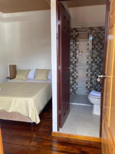 a bedroom with a bed and a shower and a toilet at Posada Casa Linda in Pijao +20 photos