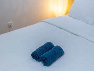 98 Apparthotel - Botanique 3 في لييج: وجود منشفة زرقاء على السرير +صورة واحدة