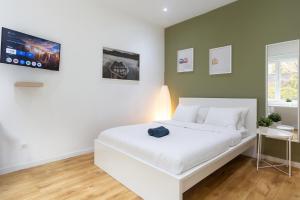 98 Apparthotel - Botanique 3 في لييج: غرفة نوم بسرير ابيض وجدار اخضر