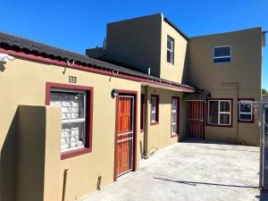 BelharUnit 1 GatherPoint Sleeps 6 Self-Catering Group in Belhar, Cape Town的几栋有着红色大门的建筑