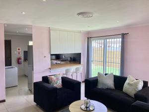 BelharUnit 1 GatherPoint Sleeps 6 Self-Catering Group in Belhar, Cape Town的带两张沙发的客厅和厨房