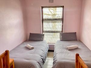 BelharUnit 1 GatherPoint Sleeps 6 Self-Catering Group in Belhar, Cape Town的一间带窗户的小房间里有两张床