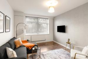 a living room with a couch and a tv at 1Bed Gem Central Bletchley Perfect for Contractors in Bletchley