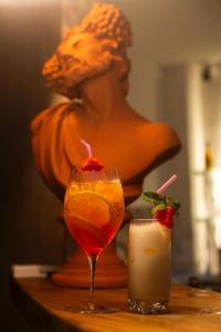 a statue of a woman sitting on a table with a drink at Olymp Spa Boutique Hotel in Monte das Gameleiras