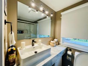 a bathroom with a white sink and a mirror at Cozy Small Room - Queen bed - Free Parking in Charlottetown in Charlottetown