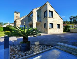 una casa con una palma di fronte di GALIHOST - Villa Gandara a Ribadumia
