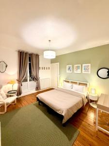 une chambre avec un grand lit et un canapé dans l'établissement Appartements Plantagenet - Le 27, au Mans