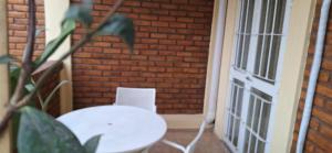 a white table and chair in front of a brick wall at Nuevo Complejo Milena in San Juan