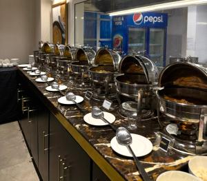a buffet line with many pots and pans of food at Taj Executive Hotel Islamabad - Luxury Stays Opposite Jinnah Super F-7 in Islamabad