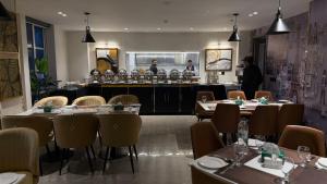 a restaurant with tables and chairs and a bar at Taj Executive Hotel Islamabad - Luxury Stays Opposite Jinnah Super F-7 in Islamabad +85 photos