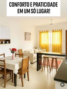 a kitchen and living room with a table and chairs at Palace Massaguaçu in Caraguatatuba +1 photo