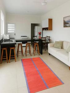 a living room with a couch and a red rug at Palace Massaguaçu in Caraguatatuba