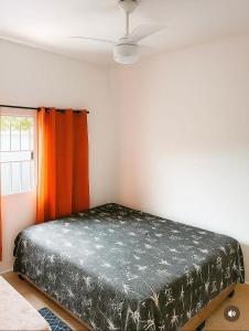a bed in a room with a ceiling fan at Palace Massaguaçu in Caraguatatuba