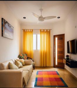 a living room with a couch and a television at Palace Massaguaçu in Caraguatatuba