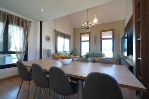 una sala da pranzo e un soggiorno con tavolo e sedie in legno di GALIHOST - Villa Gandara a Ribadumia Altre 74 foto