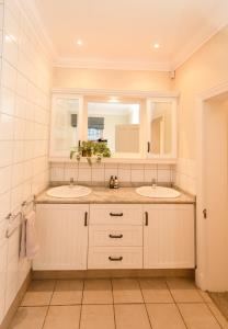 un bagno con due lavandini e uno specchio di Charming Historic Home in Central Stellenbosch a Stellenbosch