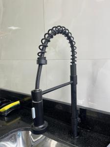 een gootsteen met een zwarte waterkraan bij Impera House Casa com piscina in Imperatriz +20 foto's