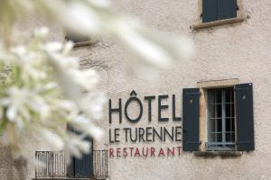 znak hotelowy na boku budynku w obiekcie Hotel Le Turenne w mieście Beaulieu-sur-Dordogne