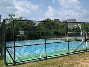 a fence around a tennis court with a basketball hoop at Apt na Amazônia in Manaus
