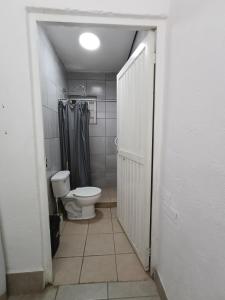 Un baño con inodoro y ducha a ras de suelo. en Departamento cerca del aeropuerto, en Chihuahua