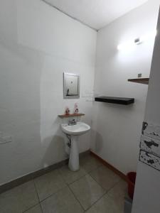 Un baño blanco con lavabo y espejo. en Departamento cerca del aeropuerto, en Chihuahua