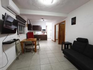 Una sala de estar y una cocina con un sofá y una mesa. en Departamento cerca del aeropuerto, en Chihuahua