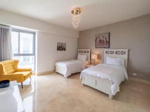 巴拿马城Habitación Royal de tres habitaciones con vista al mar的一间卧室配有两张床和一张黄色椅子