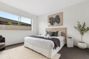 Laguna by Khove في غولد كوست: غرفة نوم بيضاء مع سرير كبير ونافذة