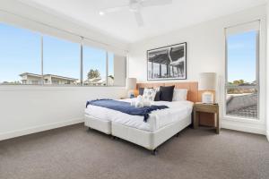 Laguna by Khove في غولد كوست: غرفة نوم بيضاء بها سرير ونوافذ كبيرة
