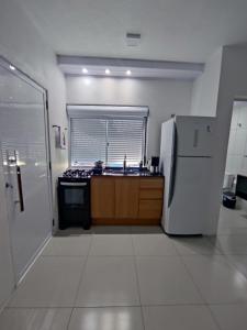 Loft Serra Gaúcha-Bem estar no coração de Nova Petrópolis في نوفا بتروبوليس: مطبخ مع ثلاجة ومغسلة +5 صور