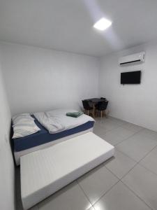 Loft Serra Gaúcha-Bem estar no coração de Nova Petrópolis في نوفا بتروبوليس: غرفة بيضاء مع سرير وطاولة