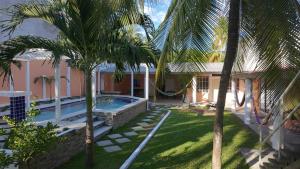 a house with a swimming pool and palm trees at Costabay in El Zapote