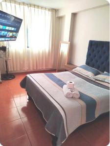 Un dormitorio con una cama con dos toallas encima. en Hermoso departamento en chorrillos, en Lima